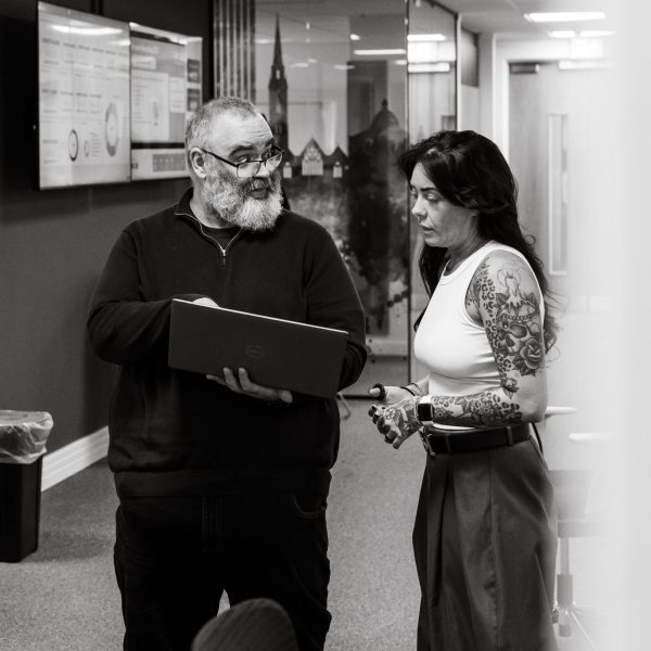 black and white photo of two members of staff talking
